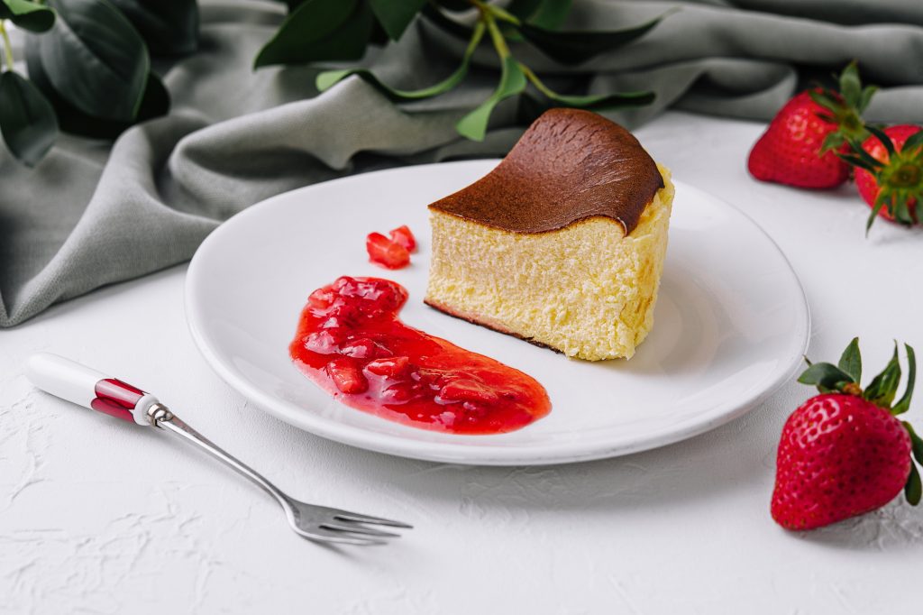 Delectable san sebastian cheesecake slice with strawberry sauce